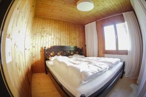a bed in a wooden room with a window at Scharnitz Chalet - gut eingerichtetes Haus in Scharnitz