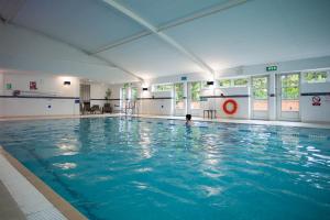 une grande piscine avec une personne dans l'eau dans l'établissement Bannatyne Hotel Durham, à Durham