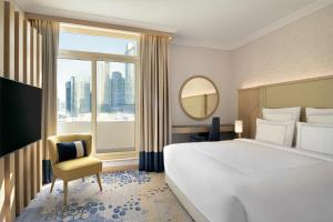 una camera d'albergo con un letto grande e una finestra di Swissôtel Al Murooj Dubai a Dubai Altre 201 foto