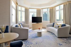 un soggiorno con due sedie e una TV a schermo piatto di Swissôtel Al Murooj Dubai a Dubai