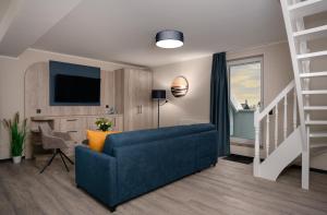 グラール・ミューリッツにあるHotel Ostseewogeの青いソファとテレビのあるリビングルーム