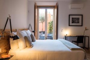 a bedroom with a bed and a desk and a window at Flora Chiado Apartments in Lisbon