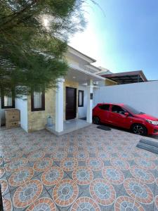 une voiture rouge garée devant une maison dans l'établissement Casa de Brisa BnB, à Prampuan