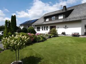 een huis met een groen gazon ervoor bij Ferienwohnungen Ingrid Alfes in Ernestus