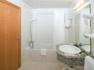 a white toilet sitting next to a shower in a bathroom at Hotel Osiris Ibiza in San Antonio