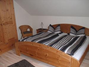 een houten bed met zwart-witte kussens erop bij Ferienwohnungen Ingrid Alfes in Ernestus