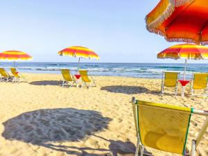 un gruppo di sedie e ombrelloni in spiaggia di Villaggio Camping Rancho a Cagnano Varano