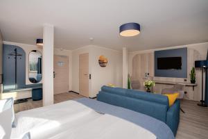 グラール・ミューリッツにあるHotel Ostseewogeのベッドルーム(青いソファ付)、リビングルーム