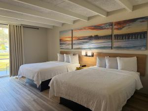 a hotel room with two beds and a painting at Days Inn by Wyndham Ocala North in Ocala +20 photos