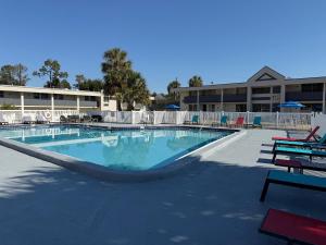 a large swimming pool in a resort with chairs and tables at Days Inn by Wyndham Ocala North in Ocala