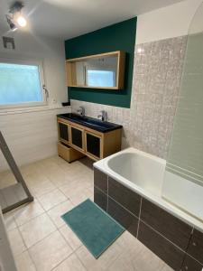 une salle de bain avec une baignoire et un lavabo dans l'établissement La maison Callinora, à La Chapelle-Saint-Étienne 13 autres photos