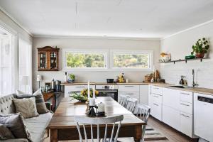 eine Küche und ein Wohnzimmer mit einem Tisch und einer Couch in der Unterkunft Family Cabin With A View in Mandal