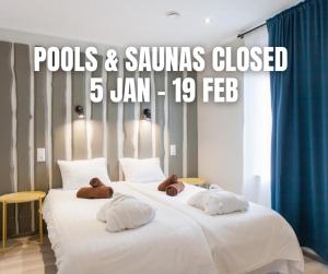 库雷萨雷Johan Suites & Spa的两张大白床,床上放着泰迪熊。