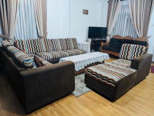 a living room with two couches and a table at Highest Village Bungalow in Nuwara Eliya