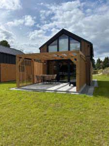 a large wooden house with a table and glass at Wrzosowisko Sominki in Sominy