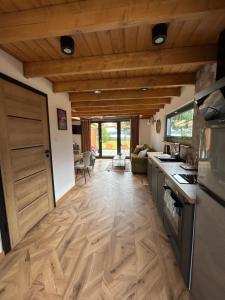 a kitchen with a wooden floor and a door at Wrzosowisko Sominki in Sominy
