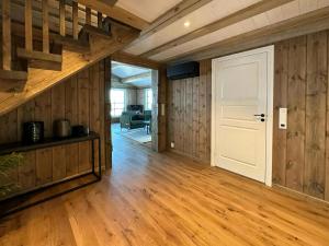 ein leeres Zimmer mit einer weißen Tür und Holzwänden in der Unterkunft Cabin With Panoramic View In Synnfjell in Nord Torpa + 9 Fotos