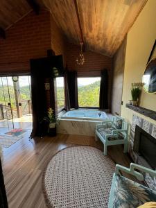 a large living room with a tub in a room at Chale Da Terra Brasil, Piscina, Hidro dupla, cozinha, lareira, vista espetacular in Santo Antônio do Pinhal +94 photos