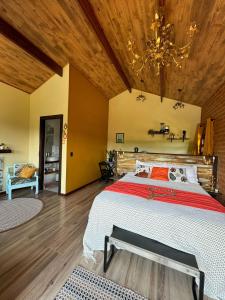 una camera da letto con un letto e un soffitto in legno di Chale Da Terra Brasil, Piscina, Hidro dupla, lareira, vista espetacular a Santo Antônio do Pinhal