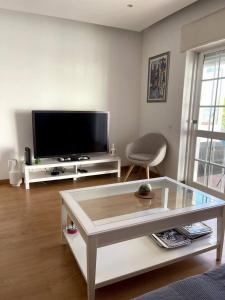 ein Wohnzimmer mit Fernseher und Couchtisch in der Unterkunft La Seixalia, charme e grande terraço in Seixal