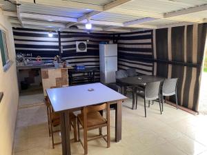een keuken met een tafel, stoelen en een koelkast bij Bedouin Village Hostel in Wadi Rum