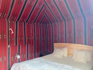 een slaapkamer met een bed met rode en blauwe muren bij Bedouin Village Hostel in Wadi Rum +43 foto's