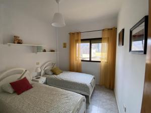 una camera da letto con due letti e una finestra di Al Magec Vacacional a Sardina