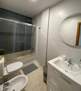 un bagno con lavandino, WC e specchio di Al Magec Vacacional a Sardina