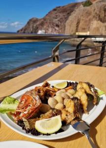 un piatto di cibo su un tavolo vicino all'oceano di Al Magec Vacacional a Sardina