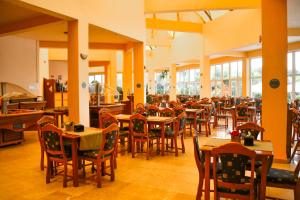 a dining room with tables and chairs and windows at COMPLEX TISMANA 3* ALL INCLUSIVE in Jupiter