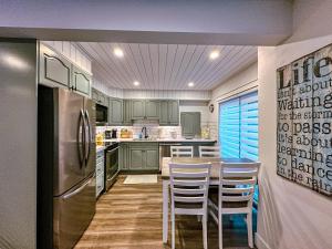 a kitchen with green cabinets and a table and chairs at Greenview Retreat in Collingwood
