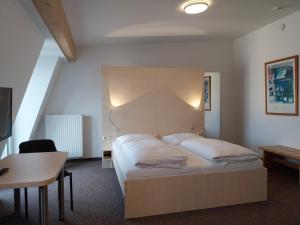 a bedroom with a bed and a table and a desk at Gästehaus Langhammer in Bubenreuth +34 photos