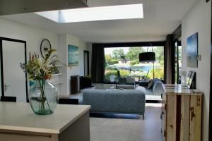 een woonkamer met een vaas met bloemen op een tafel bij OPt7 in Arnemuiden