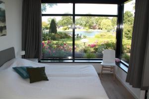 een slaapkamer met een bed en een groot raam bij OPt7 in Arnemuiden
