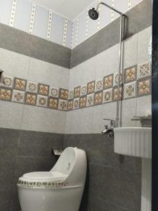 ein Badezimmer mit Toilette und Waschbecken in der Unterkunft Grand Orchard One Hotel in Lahore