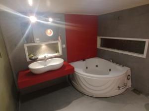 ein Badezimmer mit einer großen Badewanne, einem Waschbecken und einer Badewanne in der Unterkunft Grand Orchard One Hotel in Lahore