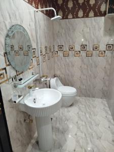 ein weißes Badezimmer mit Waschbecken und Toilette in der Unterkunft Grand Orchard One Hotel in Lahore + 29 Fotos