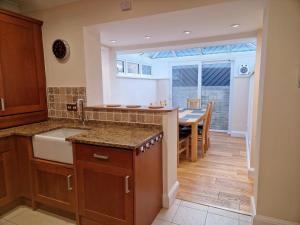 a kitchen with a sink and a table in it at Broadstairs Hideaway W Parking and Mins to Beach in Broadstairs