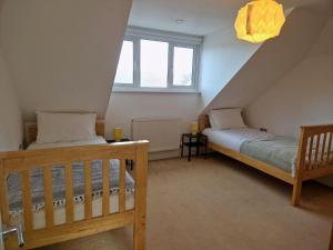 a attic bedroom with two beds and a chandelier at Broadstairs Hideaway W Parking and Mins to Beach in Broadstairs