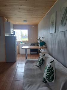 a room with a bed and a kitchen with a table at Cabaña Aeropuerto el Tepual in Puerto Montt