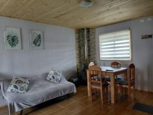 a bedroom with a table and a bed and a table and chairs at Cabaña Aeropuerto el Tepual in Puerto Montt