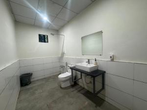 un baño con lavabo e inodoro en Tejas Gir Villa, en Sasan Gir