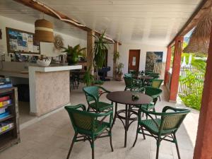 a restaurant with green chairs and tables and a counter at Le Râteau Bavoir in Calvi