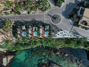 an overhead view of a resort with palm trees and water at Minareto in Siracusa