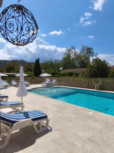 una piscina con sedie e un lampadario a braccio di Le Râteau Bavoir a Calvi