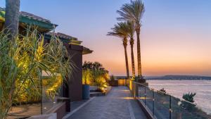 a walkway next to a house with palm trees at Minareto in Siracusa +123 photos