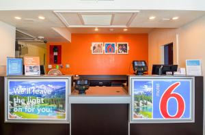 a waiting room with two signs in an orange wall at Motel 6-Pueblo, CO - I-25 in Pueblo +64 photos
