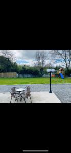 a table and two chairs and a table with umbrellas at Shangri - La Spacious Family Townhouse in Killarney