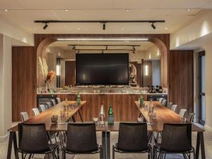 una sala de conferencias con una mesa grande y sillas en Novotel Orléans Centre Gare, en Orléans