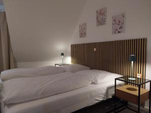 a bedroom with a large bed with two white pillows at Gästehaus Langhammer in Bubenreuth